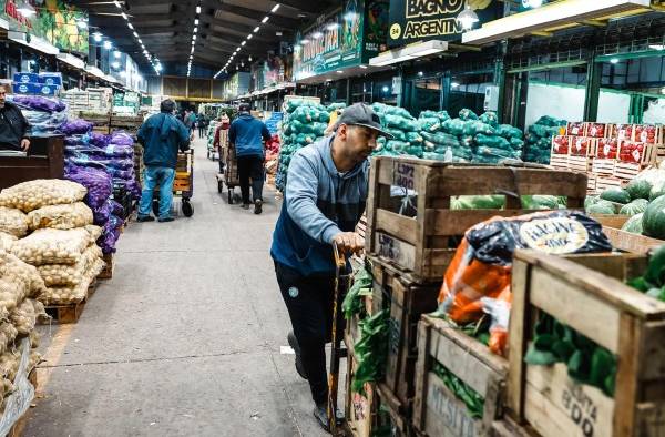 Personas realizan descarga de frutas y verduras en el mercado central de frutas y verduras en Buenos Aires, en una fotografía de archivo.