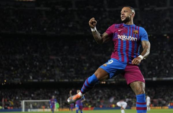 El delantero holandés del FC Barcelona Memphis Depay (d) se anticipa a Pablo Maffeo (i), defensa del Mallorca, para marcar el 1-0 en el Camp Nou