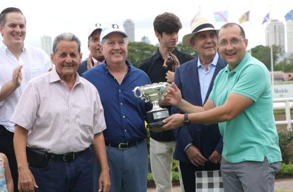 Jorge Orillac Pérez, a nombre de los homenajeados, entrega la copa del triunfo a Manuel Mata Jr.