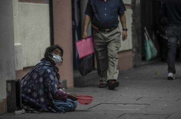 Una mujer pide dinero en la Sexta Avenida el 12 de julio 2022, en Ciudad de Guatemala