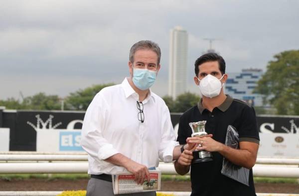 Alberto Paz Rodríguez jr. (izq.) entrega la copa del triunfo a Víctor Cardoze.