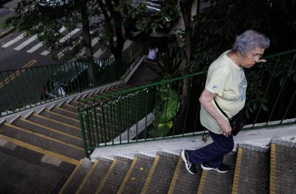 Una mujer mayor camina, por una calle de São Paulo (Brasil).