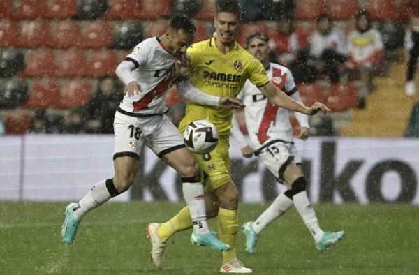 El centrocampista del Rayo Vallecano Álvaro García (i) disputa una posesión ante Juan Foyth, defensa argentino del Villareal en el Campo de Fútbol de Vallecas (Madrid).