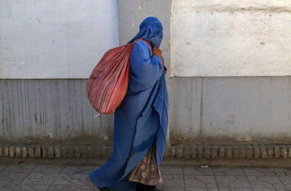 Una mujer con burka camina por una calle de Kabul, en la víspera del segundo aniversario de la victoria de los talibanes en Afganistán.