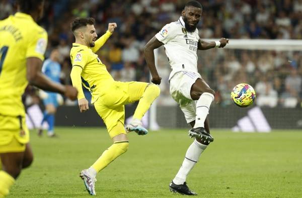 El defensa alemán del Real Madrid Antonio Rüdiger (d) controla el balón ante Álex Baena, centrocampista del Villareal (i)