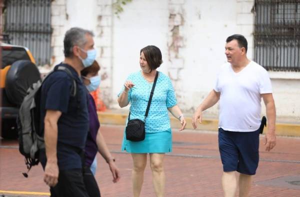 Un grupo de turistas pasean sin mascarilla en un espacio público de la Ciudad de Panamá