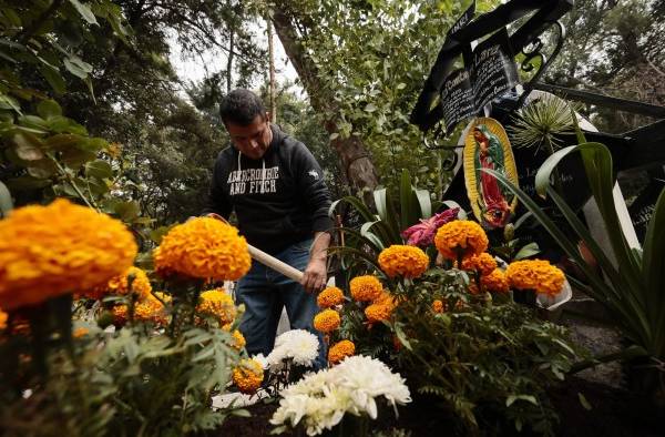 Cientos de personas acuden al Panteón de Xilotepec en la alcaldía de Xochimilco, Ciudad de México, para limpiar y adornar las tumbas de sus difuntos y recibirlos en el Día de Muertos.