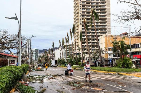 Fotografía de archivo de vecinos que caminan por una calle afectada por el paso del huracán Otis en el balneario de Acapulco, en el estado de Guerrero (México).