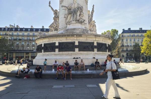 Varias personas se remojan este miércoles en una fuente ornamental de la plaza de la República de París (Francia), para hacer frente a la ola de calor.