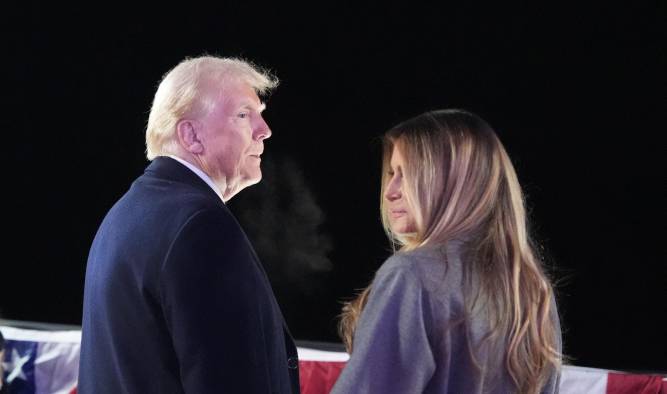 El presidente electo de Estados Unidos, Donald Trump, y su esposa Melania Trump, observan los fuegos artificiales durante una recepción en su honor en el Trump National Golf Club Washington, D. C.