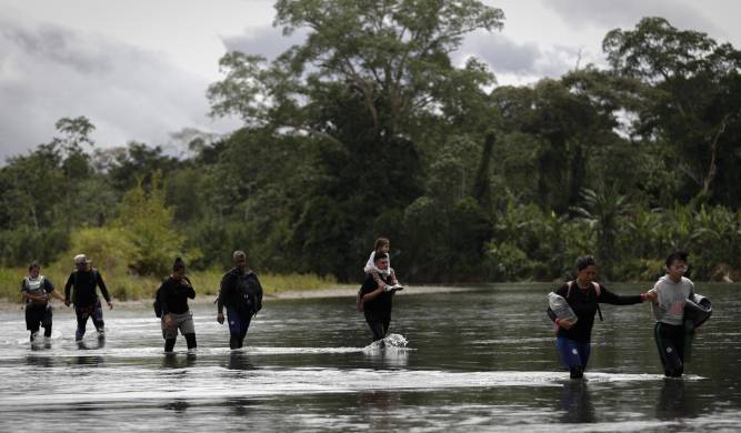 Foto de archivo de migrantes cruzando el río Tuquesa, luego de atravesar la selva de Darién.