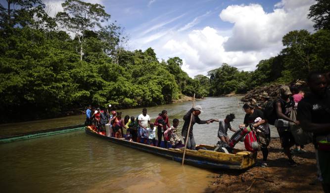 Fotografía de archivo de migrantes mientras descienden de una canoa antes de llegar a la Estación de Recepción Migratoria (ERM) de Lajas Blancas, luego de atravesar la selva del Darién.