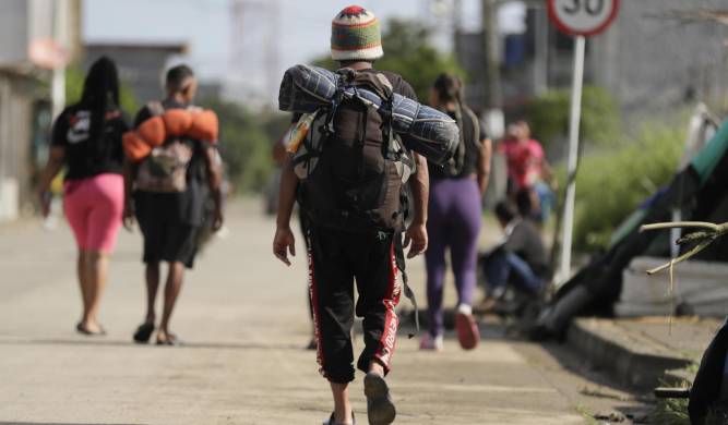 Migrantes caminan por una calle en la subregión de Urabá, en el municipio de Turbo, en Colombia.