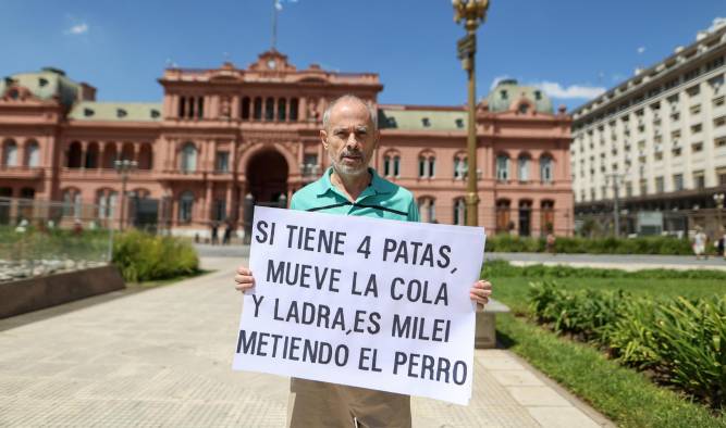 AME963. BUENOS AIRES (ARGENTINA), 17/02/2025.- Un hombre sostiene un cartel contra Javier Milei frente a la casa rosada este lunes, en Buenos Aires (Argentina).