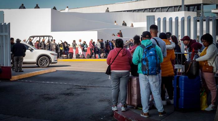 Migrantes hacen fila para solicitar un proceso de asilo en Estados Unidos, el 22 de febrero de 2024 en el paso fronterizo del Chaparral, en Baja California (México).