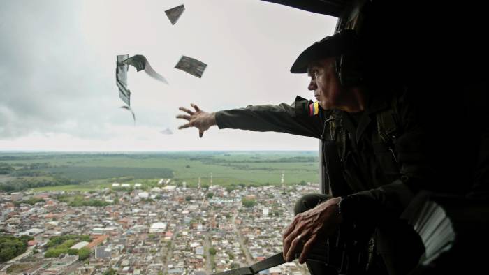 Fotografía de archivo que muestra a un oficial de la Policía lanzando volantes informativos desde un helicóptero en la región colombiana de Urabá en una campaña para invitar a la comunidad a denunciar la ubicación de los jefes del Clan del Golfo.