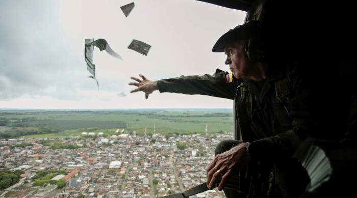 Fotografía de archivo que muestra a un oficial de la Policía lanzando volantes informativos desde un helicóptero en la región colombiana de Urabá en una campaña para invitar a la comunidad a denunciar la ubicación de los jefes del Clan del Golfo.