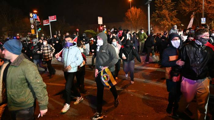 Manifestantes se retiran después de que la policía antidisturbios lanzara gases lacrimógenos durante una manifestación.