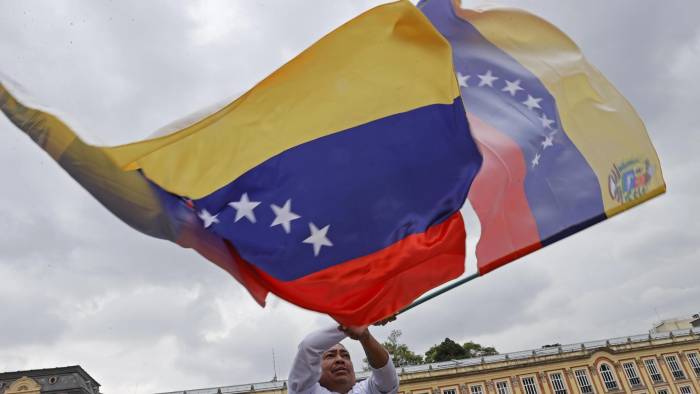 Fotografía de archivo en donde un hombre agita una bandera venezolana.