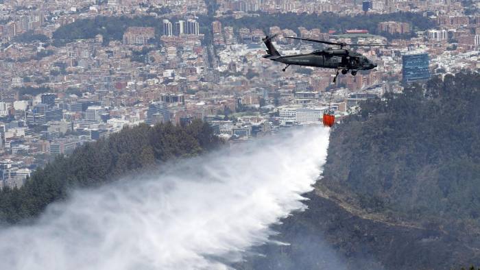 Un helicóptero de la Fuerza Aérea Colombiana (FAC) participa en labores de extinción de los incendios en los cerros orientales de Bogotá.