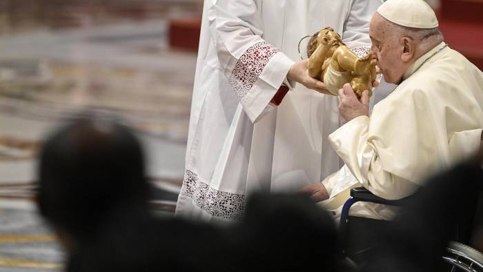 El papa besa una estatua del Niño Jesús durante la celebración de la Epifanía.