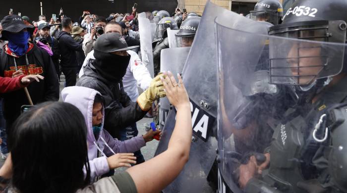Personas se enfrentan con la Policía durante una protesta hoy en Bogotá.