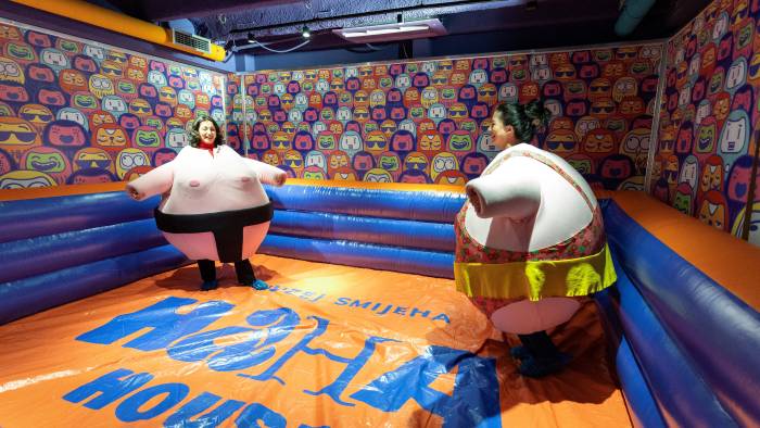 Los visitantes, vestidos con disfraces de peluche, luchan en la “arena de sumo” del museo de la risa.