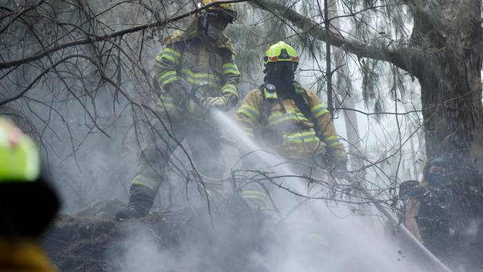 Bomberos trabajan en la extinción de un incendio, en el cerro El Cable, en Bogotá.