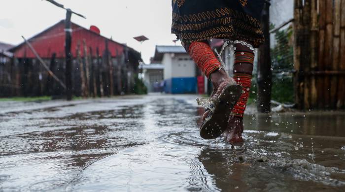 Mujer guna transita sobre los caminos inundados de la isla Gardí Sugdub.