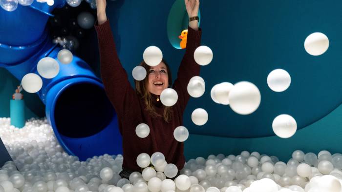 La fundadora del museo, Andrea Golubic, posa dentro de una piscina llena de pequeñas bolas blancas.