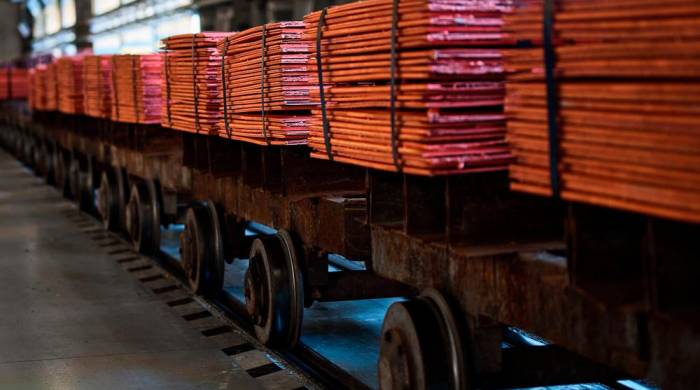 Pilas de hojas de cobre en vagones de un ferrocarril en una planta de refinería metálica.