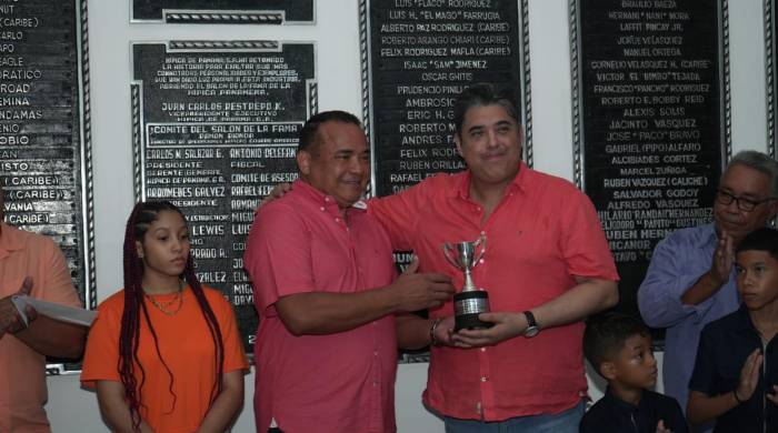 El homenajeado Arnoldo Samaniego Reyes (i) hace entrega del trofeo del triunfo a Iván Belfon.