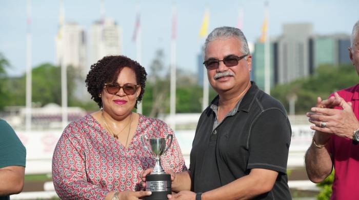 Lorna Murray, a nombre del gremio homenajeado, entrega la copa del triunfo a Fernando Carrillo.