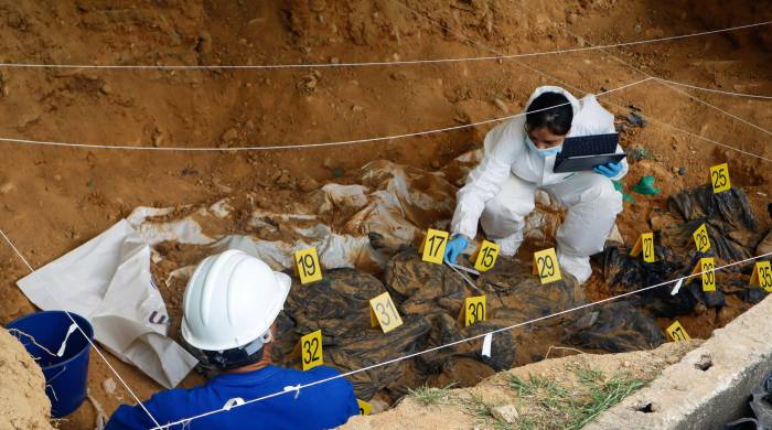 Fotografía cedida por la Jurisdicción Especial para la Paz que muestra a un grupo de forenses que trabaja en la exhumación de cuerpos.