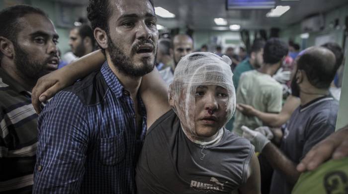 Foto de archivo de un hombre que ayuda a su hijo en el hospital de Kamal Adwan en Beit Lahia en Gaza.