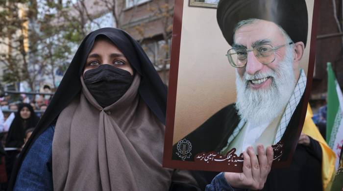 Una mujer muestra una imagen del líder supremo de Irán, Ali Jameneí, EFE/Jaime León