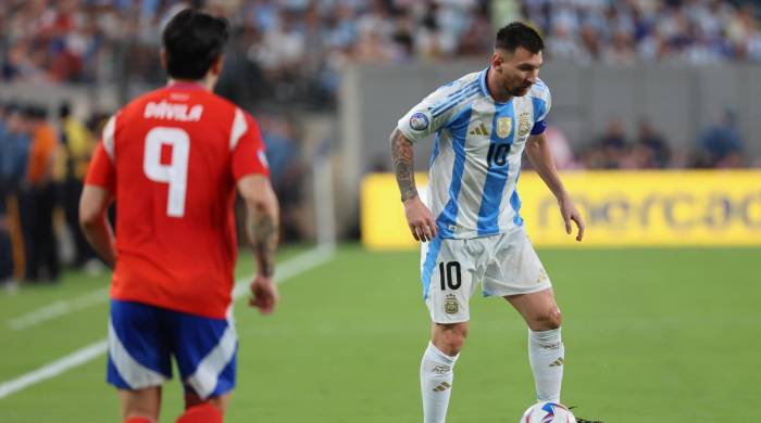 El delantero argentino Lionel Messi (der.) y el chileno Victor Davila (izq.) durante la Copa América 2024.