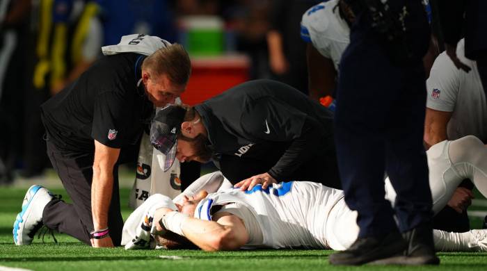 Aidan Hutchinson, de los Detroit Lions siendo atendido por el cuerpo médico del equipo, tras su lesión.