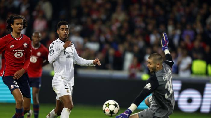 El portero francés del Lille Lucas Chevalier (d) detiene un disparo del inglés del Real Madrid, Jude Bellingham.