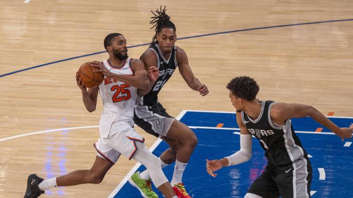 Mikal Bridges de los Knicks defiende un balón ante Devin Vassell de San Antonio Spurs durante un juego de la NBA.