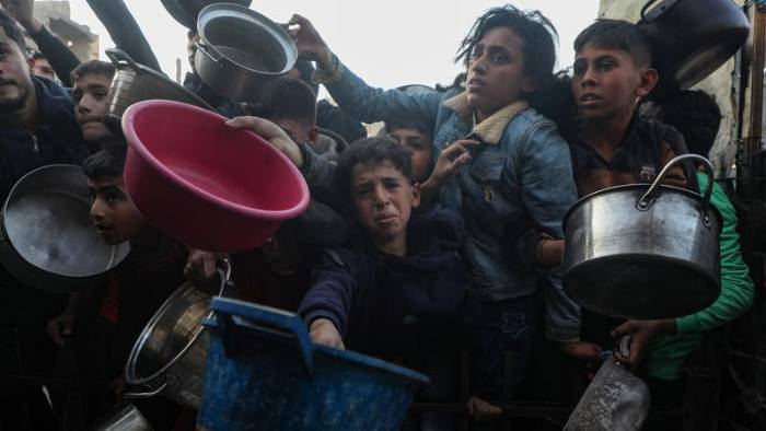 Personas intentan obtener alimentos en un comedor de beneficencia en el campamento de refugiados de Jabalia, en el norte de la Franja de Gaza, el 11 de marzo de 2025.