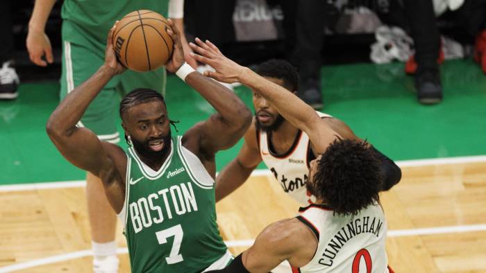 El escolta de Boston Celtics, Jaylen Brown (izq.), resiste con el balón a la presión del escolta de Detroit Pistons, Cade Cunningham.