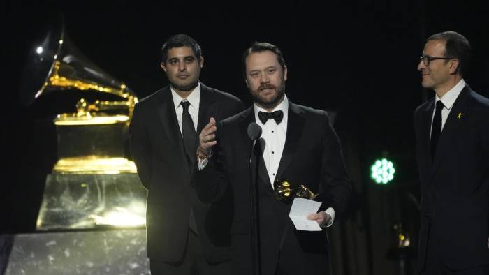 Kabir Sehgal (izq.) y Jason Carter aceptan el cuarto Grammy del exmandatario estadounidense, Jimmy Carter.