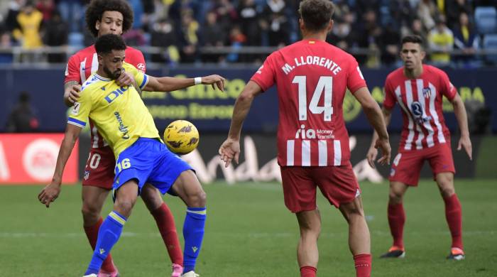 El centrocampista belga del Atlético de Madrid Axel Witsel (L) y el delantero español del Cádiz Chris Ramos compiten por el balón.