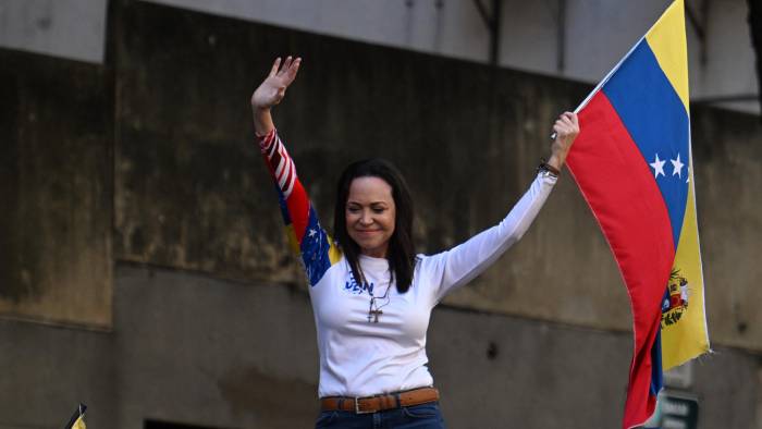 La líder opositora venezolana María Corina Machado ondea una bandera nacional durante una protesta convocada por la oposición en vísperas de la investidura presidencial, en Caracas el 9 de enero de 2025.