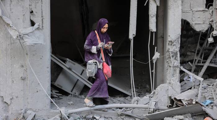 Una mujer entre los escombros de un edificio destruido durante el bombardeo israelí en el barrio Sheikh Radwan de la ciudad de Gaza.