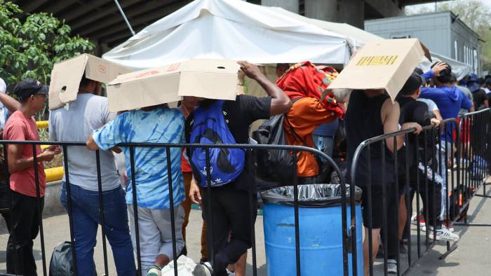 Migrantes permanecen en un punto de revisión del Instituto Nacional de Migración para entregarse y ser trasladados a Tuxtla Gutiérrez, en Chiapas.