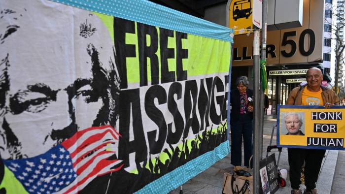 Supporters of WikiLeaks founder Julian Assange hold banners and placards as they protest in support of him outside the US Consulate General in Sydney on June 26, 2024. - A US judge freed Julian Assange on June 26 in a plea deal that ends years of legal drama for the WikiLeaks founder, long wanted by Washington for revealing military secrets.