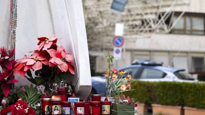 Flores y velas depositadas al pie de la estatua de Juan Pablo II ante la entrada del Hospital Universitario Gemelli de Roma, donde permanece ingresado el papa Francisco.