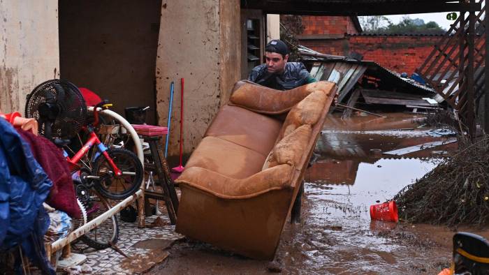 Everton Lemes intenta rescatar un sofá afectados por una inundación este domingo en el municipio de Río Pardo, estado de Rio Grande do Sul (Brasil).